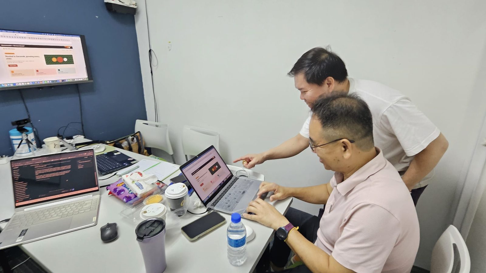 Damien Goh and Francis Lee reviewing the childcare centre website on a laptop during the hackathon build
